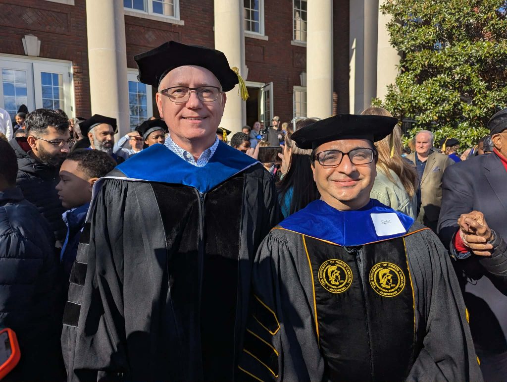 Dr. Dan Royall and Dr. Rajesh Sigdel outside after the December 2025 graduation ceremony.